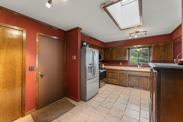 7567 Lent Trl, Lent Twp, MN 55079 - kitchen with appliances with stainless steel finishes, crown molding, light tile patterned floors, a skylight, and brown cabinetry