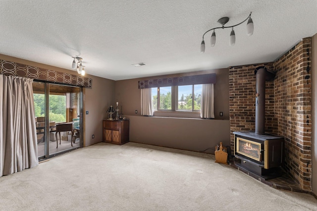 7567 Lent Trl, Lent Twp, MN 55079 - unfurnished living room with a textured ceiling, carpet floors, and a wood stove