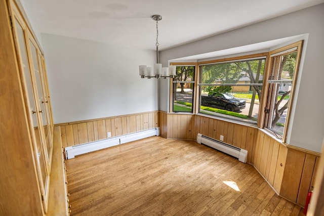 4922 Sheridan Ave S, Minneapolis, MN 55410 - unfurnished dining area featuring a baseboard heating unit, light wood-style floors, a wainscoted wall, wooden walls, and a chandelier