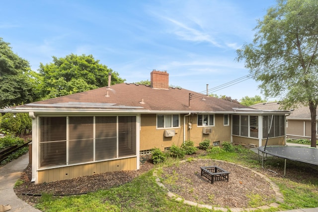 4922 Sheridan Ave S, Minneapolis, MN 55410 - back of house featuring a sunroom, a chimney, an outdoor fire pit, a trampoline, and roof with shingles