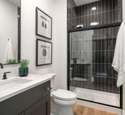 bathroom with vanity, toilet, and a tile shower