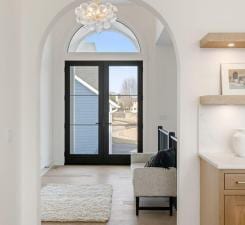 doorway to outside with arched walkways and a chandelier