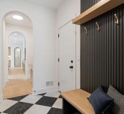 mudroom with tile patterned floors, arched walkways, and baseboards