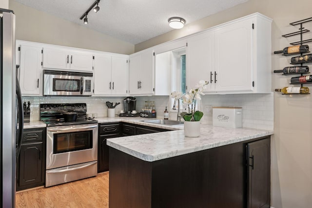 20561 Jade Cir, Lakeville, MN 55044 - kitchen featuring stainless steel appliances, a textured ceiling, white cabinetry, light countertops, and a sink