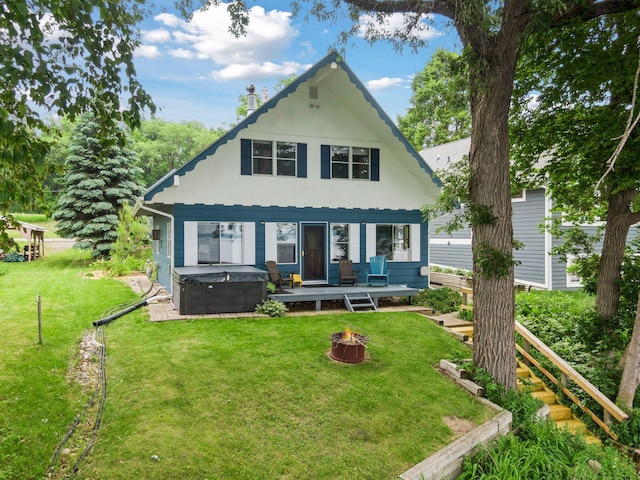 3886 Eagle Rd, Willmar, MN 56201 - back of house with a hot tub, a fire pit, a lawn, and a deck