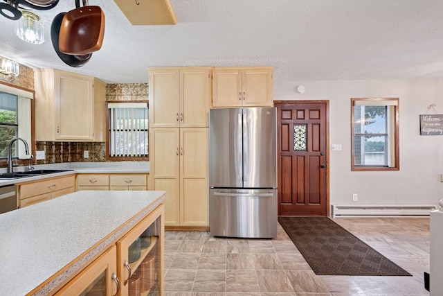 3886 Eagle Rd, Willmar, MN 56201 - kitchen featuring freestanding refrigerator, a baseboard radiator, light brown cabinets, light countertops, and a textured ceiling