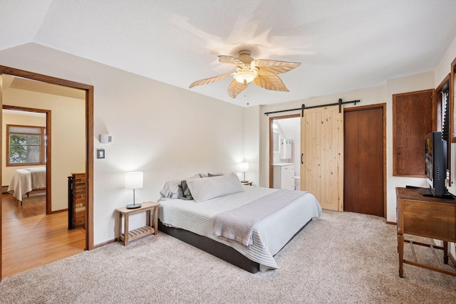 3886 Eagle Rd, Willmar, MN 56201 - bedroom with light carpet, a barn door, ceiling fan, ensuite bathroom, and a closet