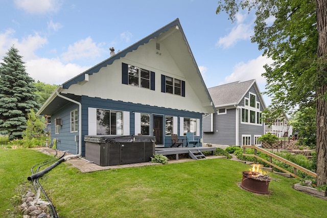 3886 Eagle Rd, Willmar, MN 56201 - rear view of property featuring a hot tub, an outdoor fire pit, a deck, and a lawn