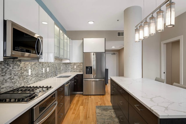 1240 2nd St Unit 1120, Minneapolis, MN 55415 - kitchen with appliances with stainless steel finishes, a sink, modern cabinets, white cabinets, and light wood-style floors