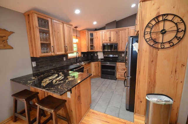 12207 285th St, Lindstrom, MN 55045 - kitchen with double oven range, a peninsula, freestanding refrigerator, tasteful backsplash, and vaulted ceiling