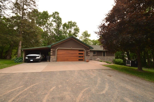 12207 285th St, Lindstrom, MN 55045 - view of front of house with stone siding, concrete driveway, an attached garage, and an attached carport