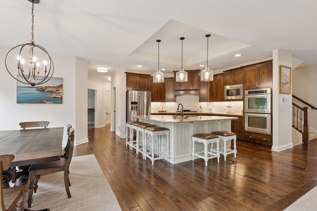 11668 Azure Ct, Inver Grove Heights, MN 55077 - kitchen featuring stainless steel appliances, a tray ceiling, a chandelier, tasteful backsplash, and dark wood finished floors