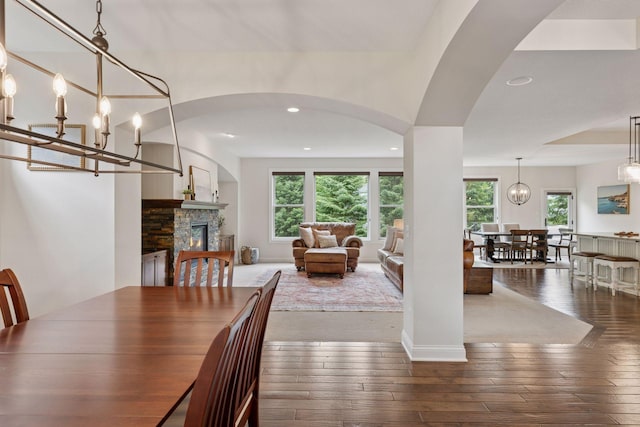 11668 Azure Ct, Inver Grove Heights, MN 55077 - dining space featuring healthy amount of natural light, a stone fireplace, wood-type flooring, recessed lighting, and arched walkways