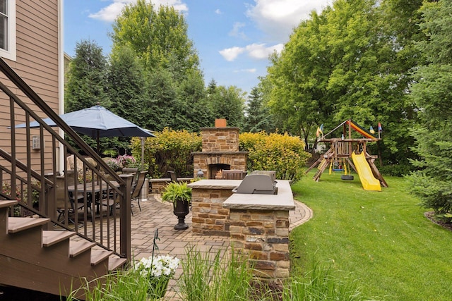 11668 Azure Ct, Inver Grove Heights, MN 55077 - view of patio with an outdoor stone fireplace, stairs, a playground, and view of scattered trees