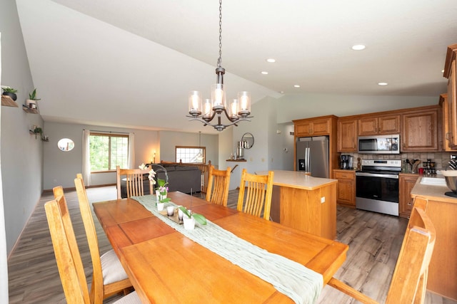 1406 English Ave NW, New Prague, MN 56071 - dining space with lofted ceiling, light wood finished floors, a chandelier, and recessed lighting