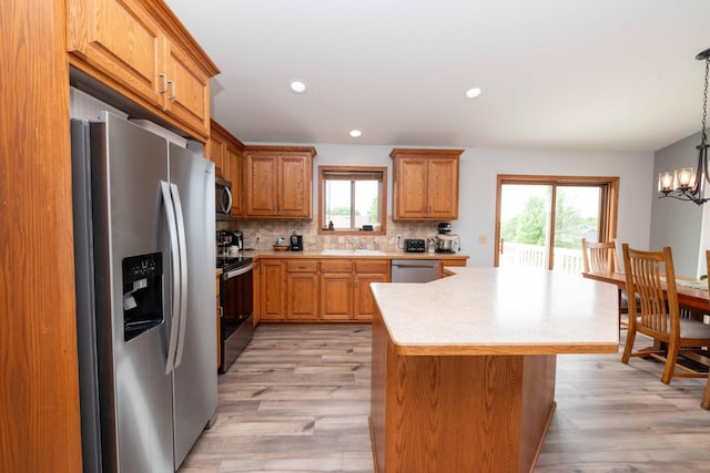 1406 English Ave NW, New Prague, MN 56071 - kitchen with stainless steel appliances, healthy amount of natural light, light countertops, light wood-style floors, and recessed lighting