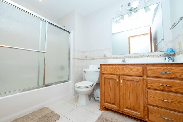 1406 English Ave NW, New Prague, MN 56071 - full bath with tile patterned floors, vanity, combined bath / shower with glass door, a wainscoted wall, and tile walls