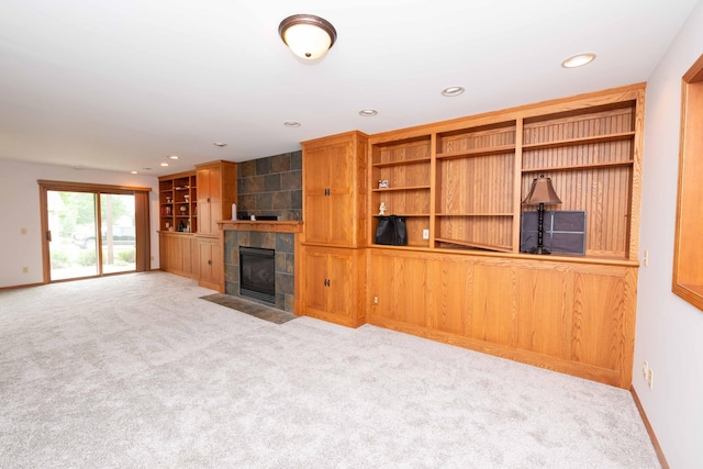 1406 English Ave NW, New Prague, MN 56071 - unfurnished living room with carpet flooring, a tiled fireplace, recessed lighting, and built in shelves