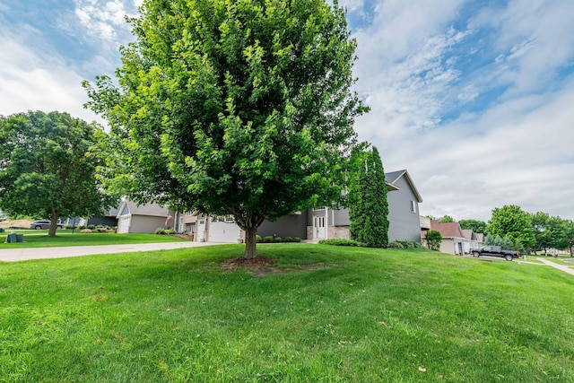 1406 English Ave NW, New Prague, MN 56071 - obstructed view of property featuring concrete driveway, a front yard, and brick siding