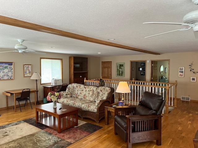 6460 Mountain Maple Ln NW, Walker, MN 56484 - living area with a ceiling fan, light wood finished floors, beam ceiling, a textured ceiling, and baseboards