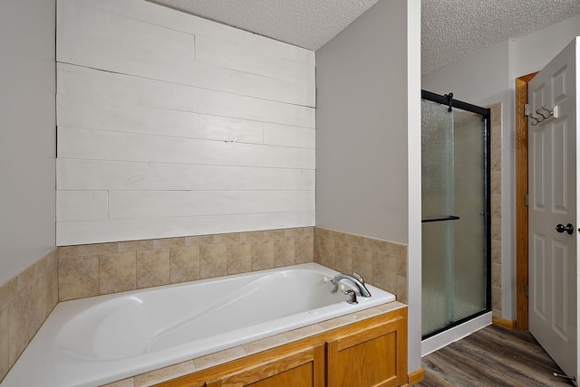 7331 Lamont Ave NE, Otsego, MN 55301 - full bathroom with a shower stall, a bath, wood finished floors, and a textured ceiling
