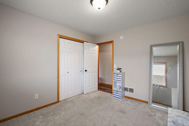 7331 Lamont Ave NE, Otsego, MN 55301 - unfurnished bedroom with carpet flooring, a closet, and a textured ceiling