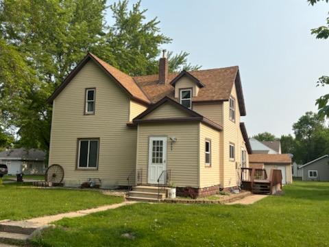 664 12th St, Windom, MN 56101 - back of house featuring a yard, a chimney, and a wooden deck