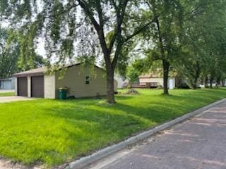 664 12th St, Windom, MN 56101 - view of home's exterior featuring a garage and a lawn