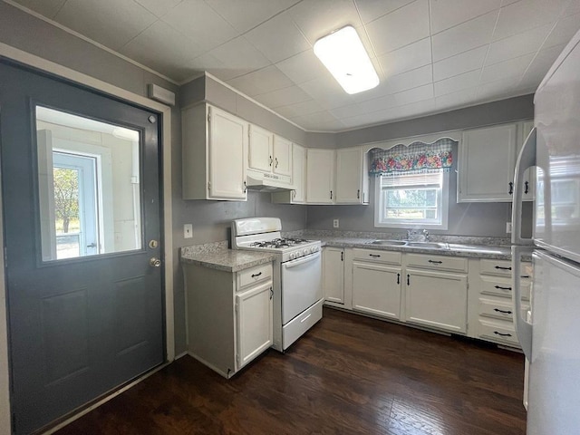 810 Charles St, Park Rapids, MN 56470 - kitchen with white appliances, under cabinet range hood, a sink, dark wood-style floors, and white cabinetry