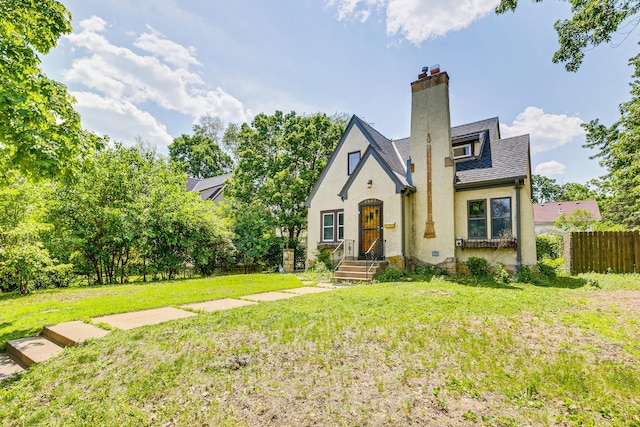 3807 Hubbard Ave N, Robbinsdale, MN 55422 - tudor house featuring a chimney, stucco siding, and roof with shingles