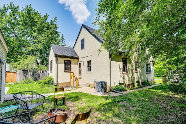 3807 Hubbard Ave N, Robbinsdale, MN 55422 - rear view of property with stucco siding, an outdoor fire pit, and a shingled roof