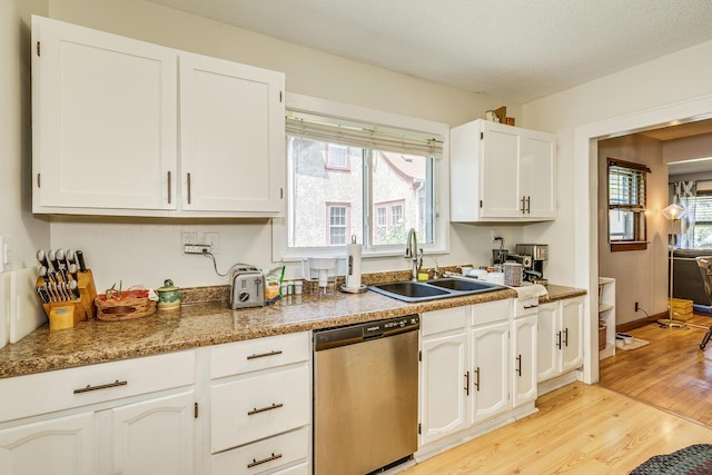 3807 Hubbard Ave N, Robbinsdale, MN 55422 - kitchen featuring stainless steel dishwasher, a sink, light wood finished floors, and white cabinetry