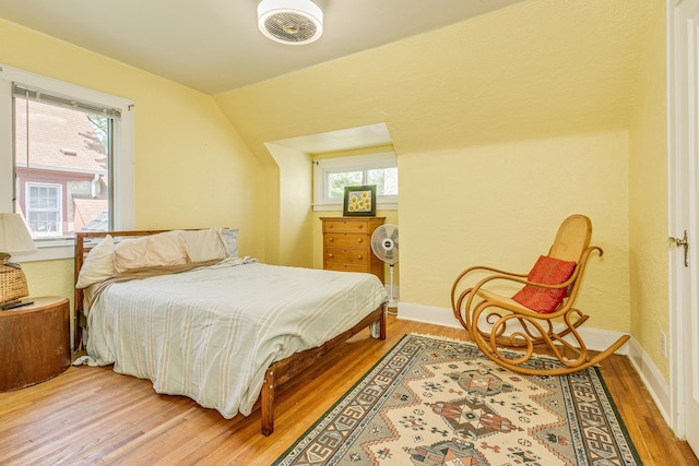 3807 Hubbard Ave N, Robbinsdale, MN 55422 - bedroom featuring light wood-style floors, baseboards, multiple windows, and vaulted ceiling