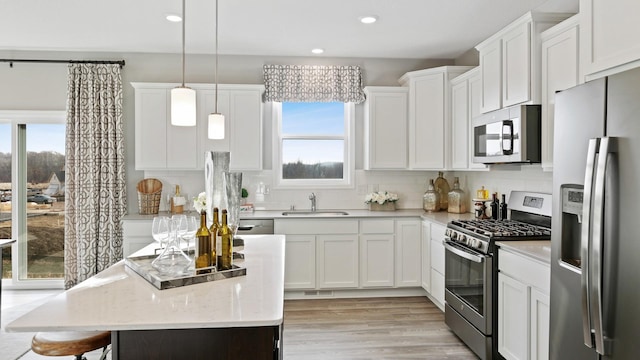 1064 Aster Blvd, Rosemount, MN 55068 - kitchen featuring appliances with stainless steel finishes, a sink, backsplash, white cabinets, and a center island