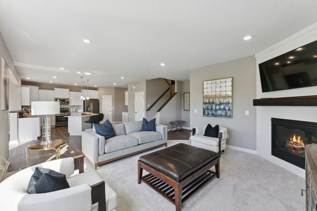 1064 Aster Blvd, Rosemount, MN 55068 - living area with recessed lighting, a large fireplace, baseboards, light carpet, and stairs