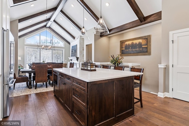 4110 Osprey Ct NE, Prior Lake, MN 55372 - kitchen featuring a kitchen bar, beamed ceiling, dark wood-style flooring, dark brown cabinets, and light countertops
