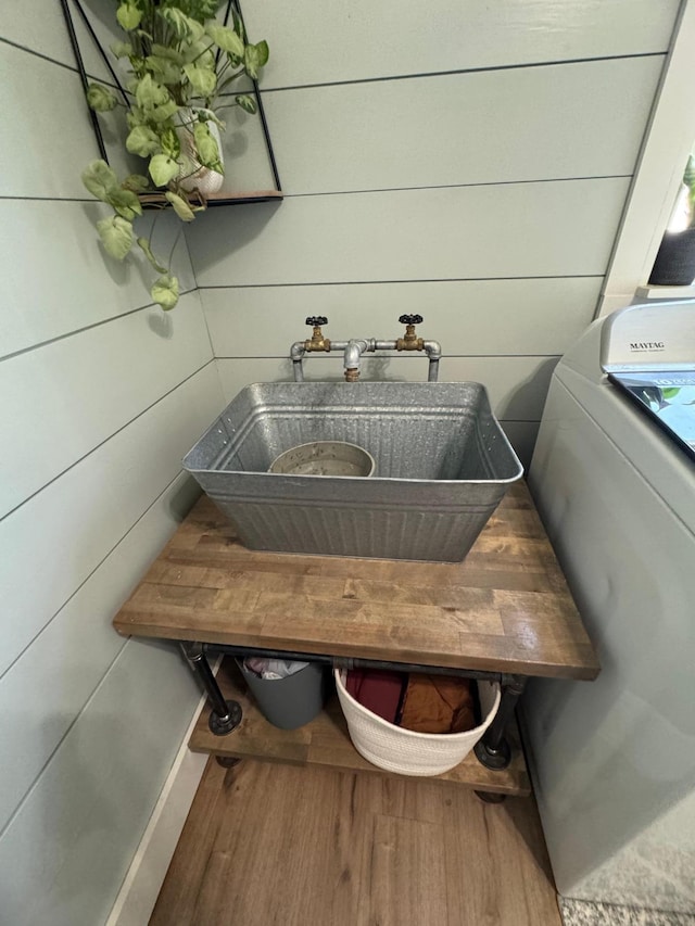 8339 71st St, West Concord, MN 55985 - detailed view of washer / clothes dryer, a sink, and wood finished floors