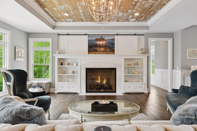 3758 Woodland Cove Pkwy, Minnetrista, MN 55331 - living area with ornamental molding, a raised ceiling, a chandelier, hardwood / wood-style flooring, and a high end fireplace