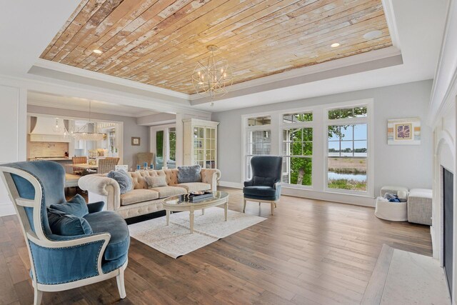 3758 Woodland Cove Pkwy, Minnetrista, MN 55331 - living room with a raised ceiling, a chandelier, crown molding, wood-type flooring, and a high end fireplace