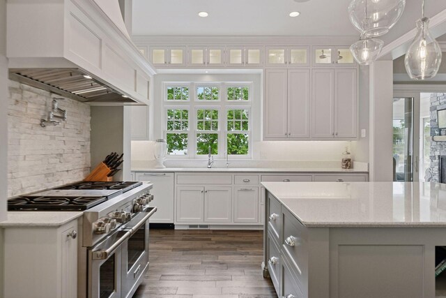 3758 Woodland Cove Pkwy, Minnetrista, MN 55331 - kitchen with range with two ovens, custom exhaust hood, white cabinetry, dark wood finished floors, and recessed lighting