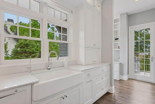 3758 Woodland Cove Pkwy, Minnetrista, MN 55331 - kitchen featuring white cabinetry, dark wood finished floors, glass insert cabinets, and light stone counters