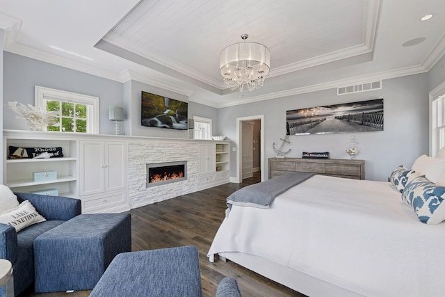 3758 Woodland Cove Pkwy, Minnetrista, MN 55331 - bedroom with a tray ceiling, a chandelier, dark wood-style floors, crown molding, and a stone fireplace