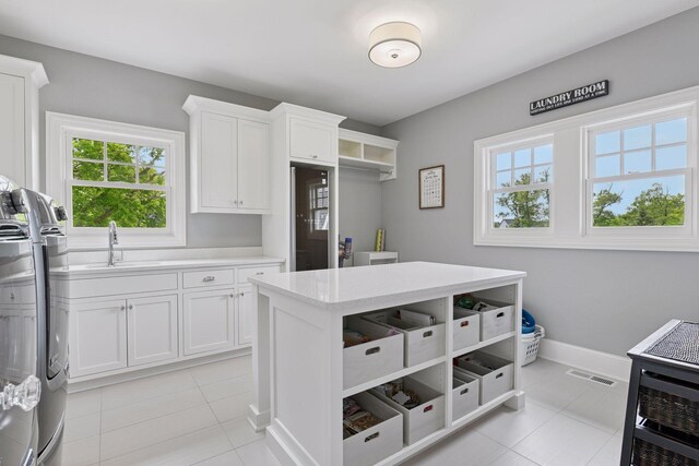 3758 Woodland Cove Pkwy, Minnetrista, MN 55331 - laundry room with cabinet space, light tile patterned floors, and washing machine and clothes dryer