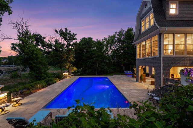 3758 Woodland Cove Pkwy, Minnetrista, MN 55331 - pool at dusk featuring a patio and an outdoor pool