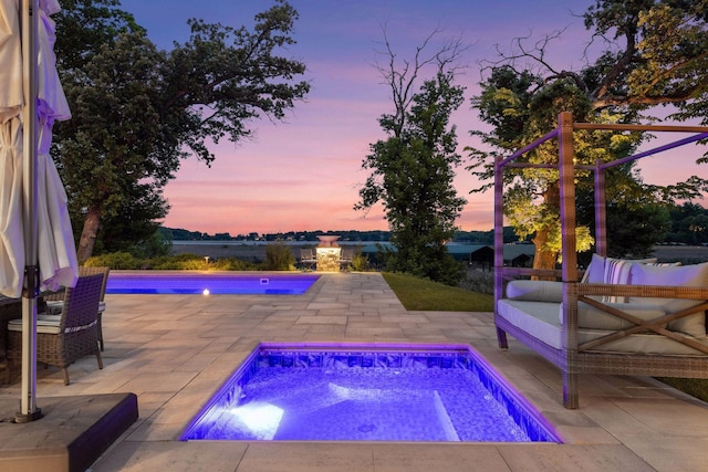 3758 Woodland Cove Pkwy, Minnetrista, MN 55331 - pool at dusk featuring an in-ground hot tub, a patio area, and an outdoor pool