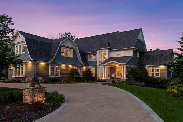 3758 Woodland Cove Pkwy, Minnetrista, MN 55331 - view of front facade with curved driveway, a shingled roof, and a front yard
