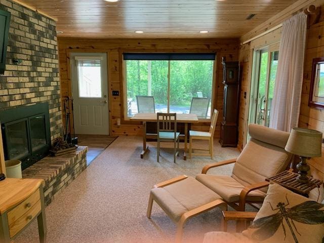 6543 Point Dr, Ideal Twp, MN 56474 - dining room featuring wooden ceiling, healthy amount of natural light, wooden walls, and light colored carpet