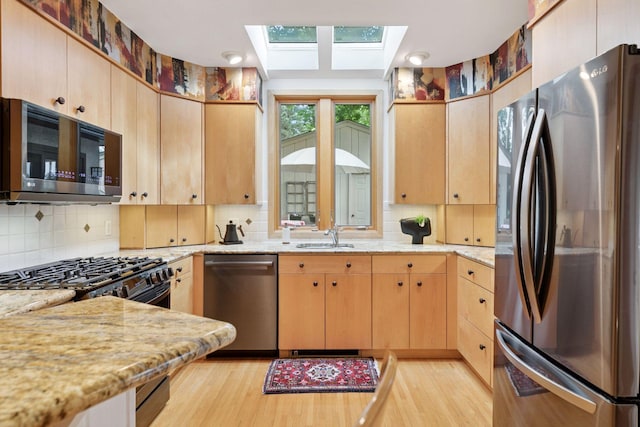 2248 Goodrich Ave, Saint Paul, MN 55105 - kitchen featuring stainless steel appliances, a skylight, decorative backsplash, and light wood finished floors