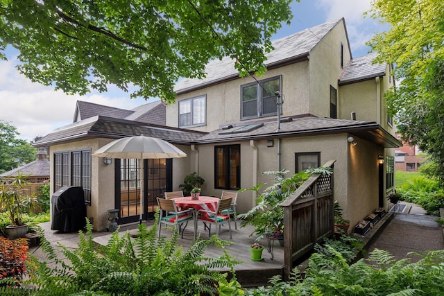 2248 Goodrich Ave, Saint Paul, MN 55105 - rear view of house featuring stucco siding, a deck, and outdoor dining space