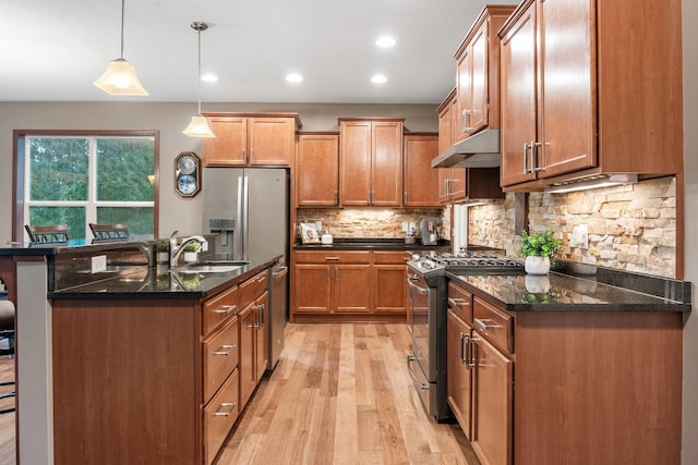 4027 148th Ln NE, Ham Lake, MN 55304 - kitchen with appliances with stainless steel finishes, light wood-type flooring, under cabinet range hood, a kitchen breakfast bar, and brown cabinetry